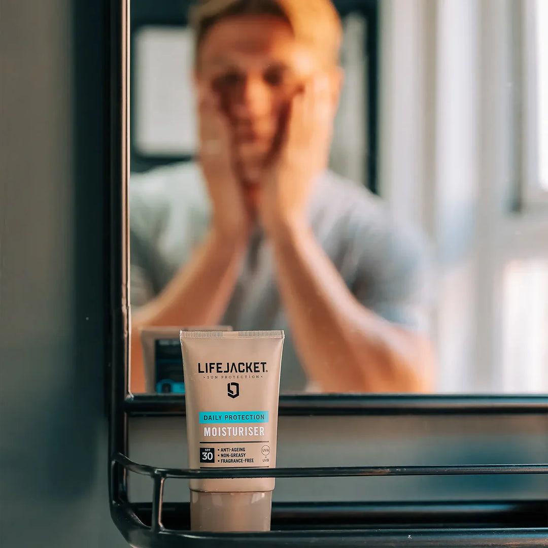 Man applies lifejacket in the mirror.