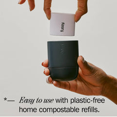 Hands holding Fussy deodorant with compostable refill, plastic-free packaging, easy to use