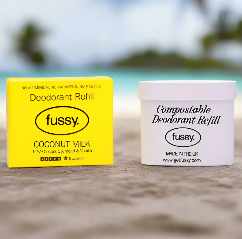 Fussy coconut milk deodorant refill and compostable deodorant container on a beach