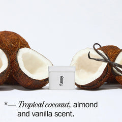 Fussy deodorant with halved coconuts, almond, and vanilla pods on white background