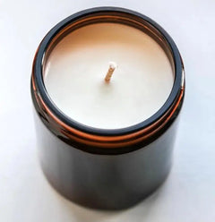 Soy wax candle in amber glass jar on white background