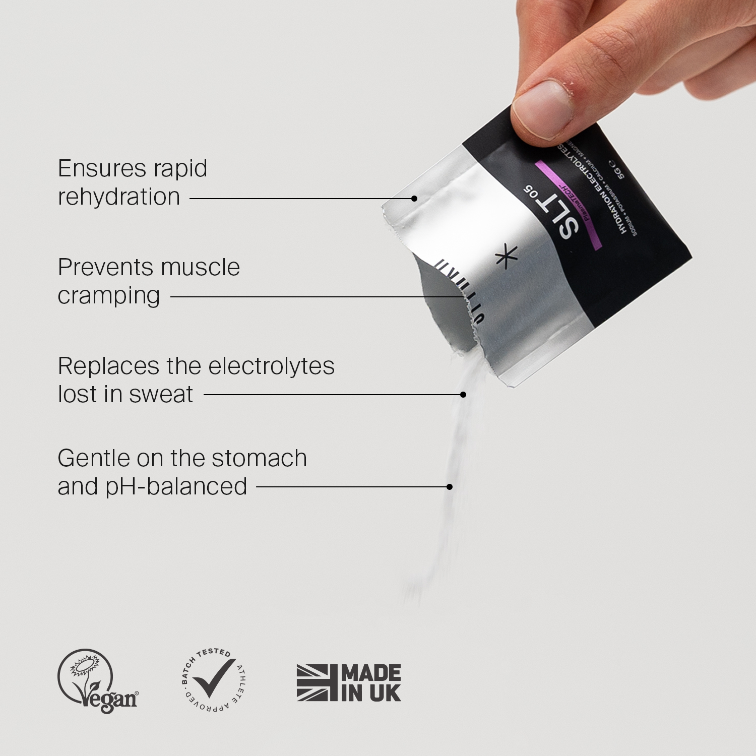 Hand pouring SLT-05 electrolyte powder sachet with benefits and vegan, UK made icons.