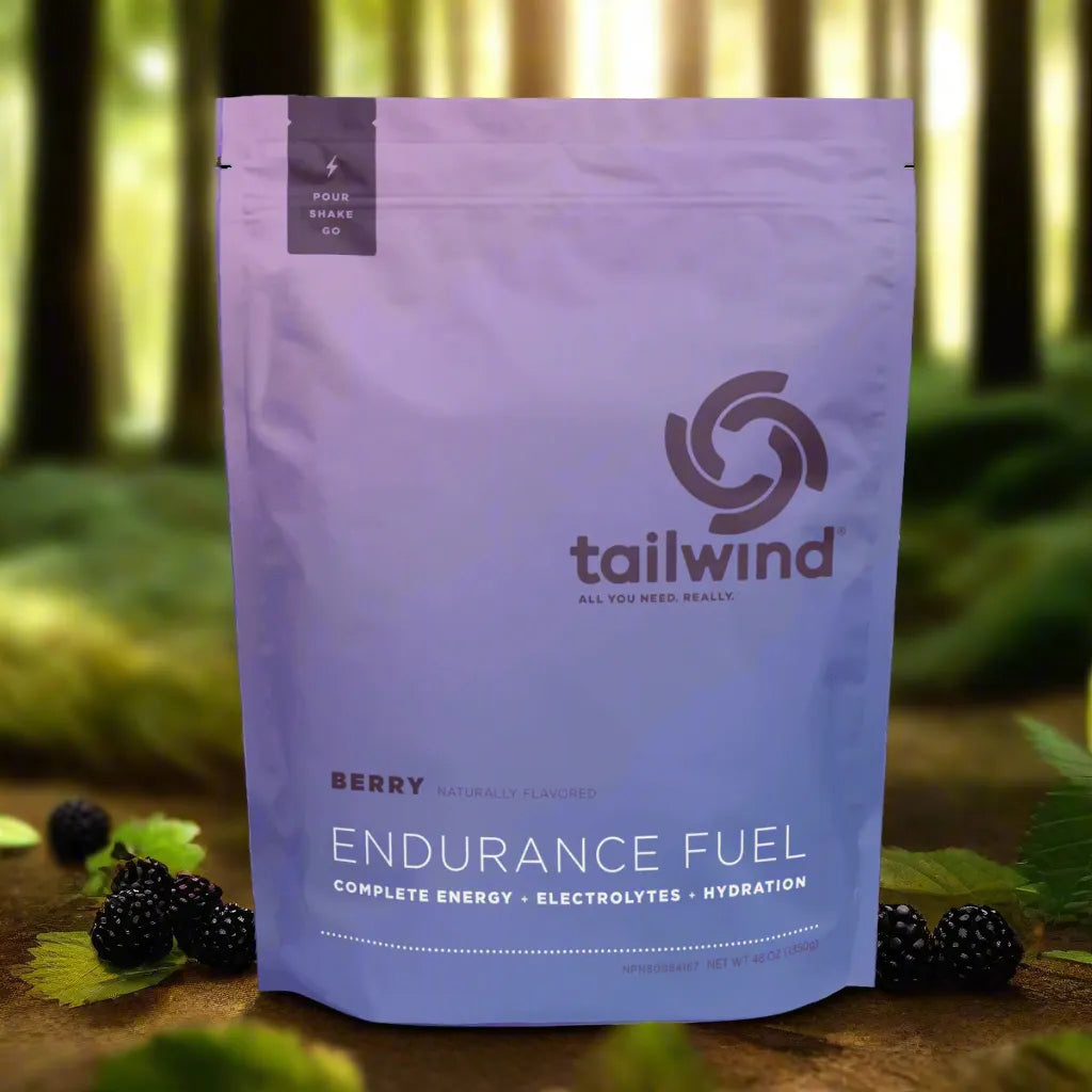 Tailwind Endurance Fuel berry flavor electrolyte drink powder in a forest with blackberries