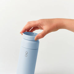 Hand opening light blue Brew 350ml insulated bottle on white background
