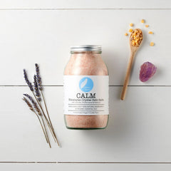 Calm Himalayan crystal bath salts jar with lavender, resin, and amethyst on white wood