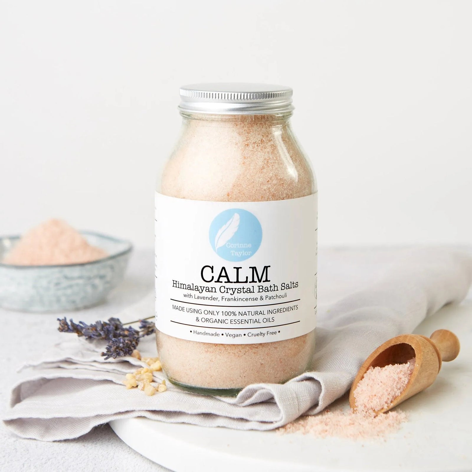 Calm Himalayan crystal bath salts jar with wooden scoop, lavender, and natural decor