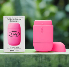 Fussy coconut milk refillable natural deodorant in pink case with packaging on green background