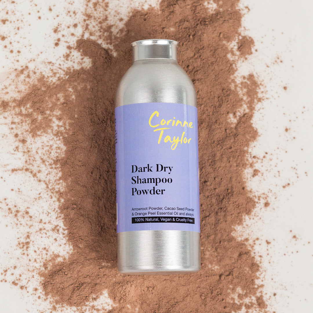 Corinne Taylor Dark Dry Shampoo Powder bottle on scattered dark powder, vegan and natural product