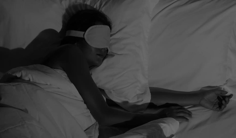 Person sleeping comfortably in a dark bedroom