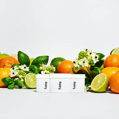 Fussy deodorant containers with fresh citrus fruits, green leaves, and white flowers