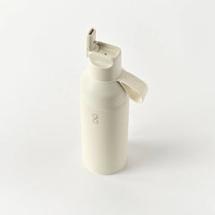 Sandstone reusable water bottle with flip spout and Ocean Bottle logo on white background