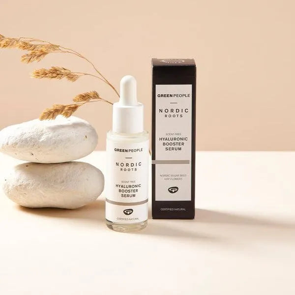 Green People Nordic Roots hyaluronic booster serum bottle and box on beige background