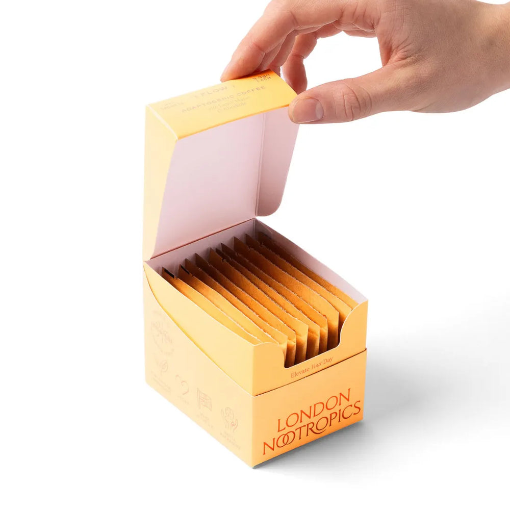 Hand opening London Nootropics Flow Coffee sachet box on white background
