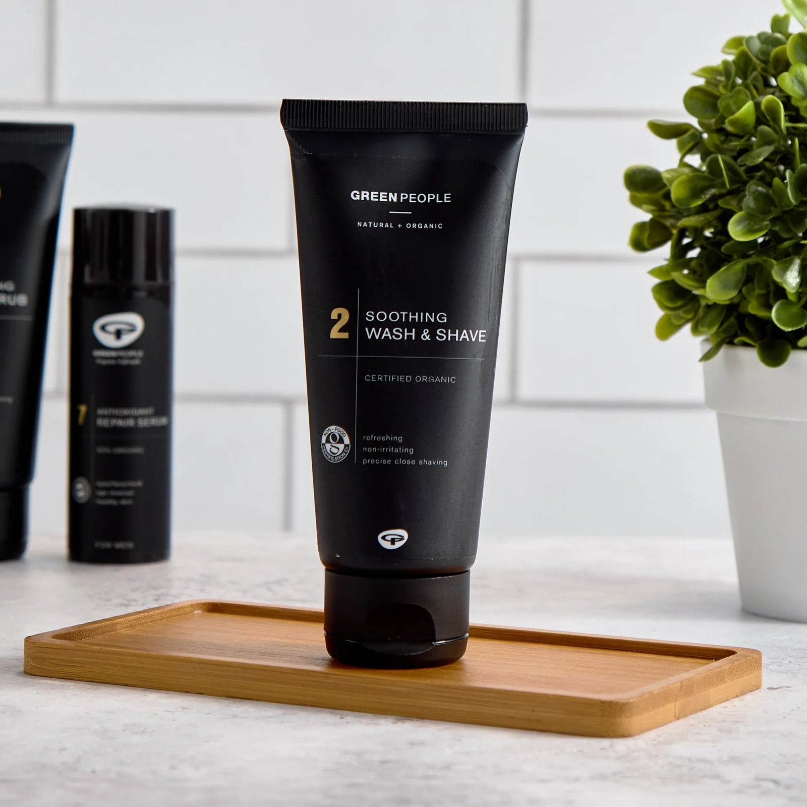 Green People Soothing Wash & Shave organic skincare tube on bamboo tray in modern bathroom