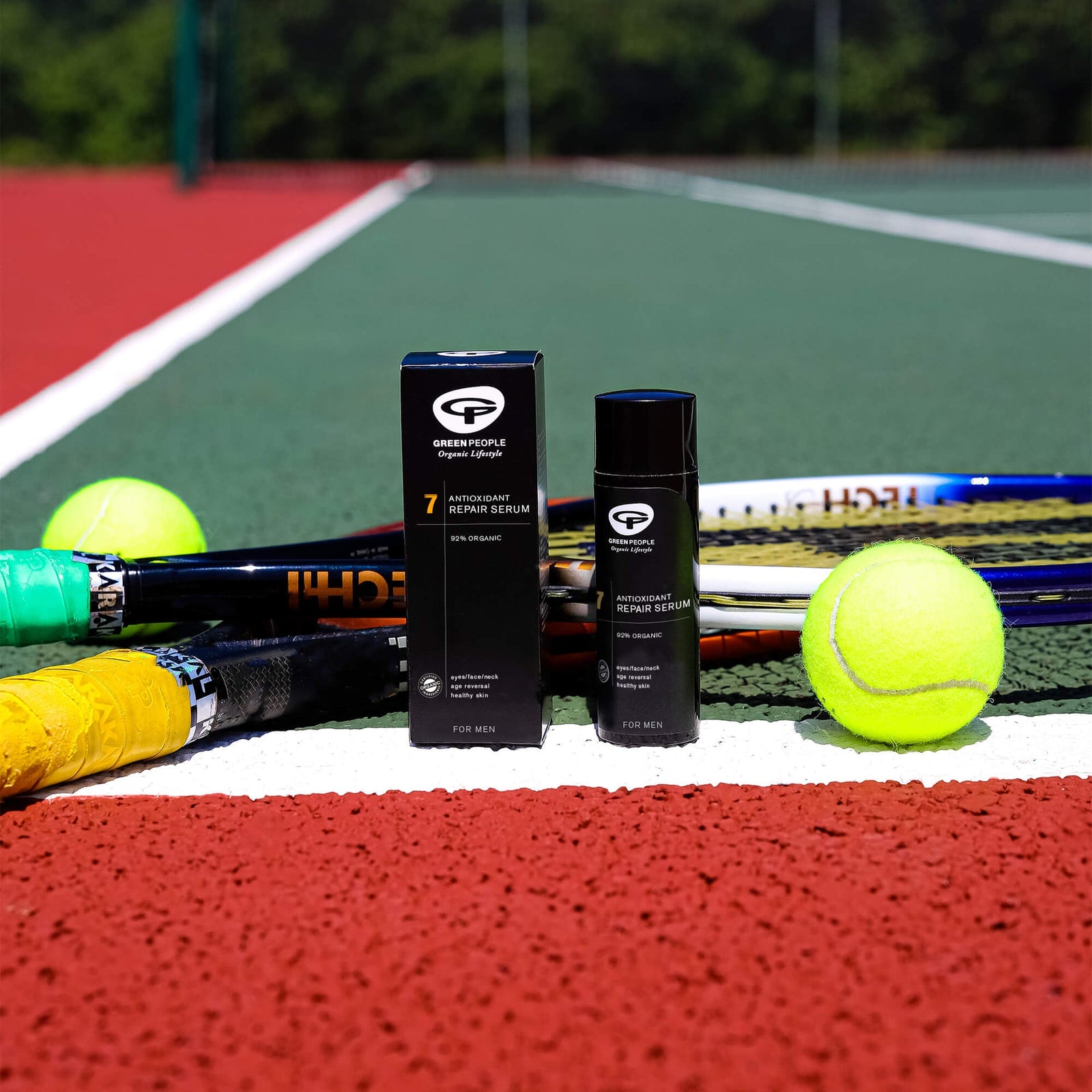 Green People Antioxidant Repair Serum for men on tennis court with rackets and tennis balls