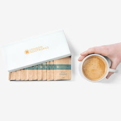 London Nootropics Mojo coffee sachets box with a hand holding a cup of coffee on white background