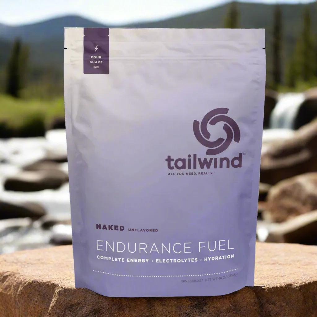 Tailwind Endurance Fuel Naked Unflavored powder on rock by river with mountain background