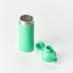 Green stainless steel reusable water bottle with two caps on white background