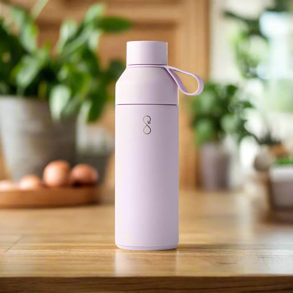 Lavender Haze OG 500ml reusable water bottle on wooden table, minimalist kitchen setting