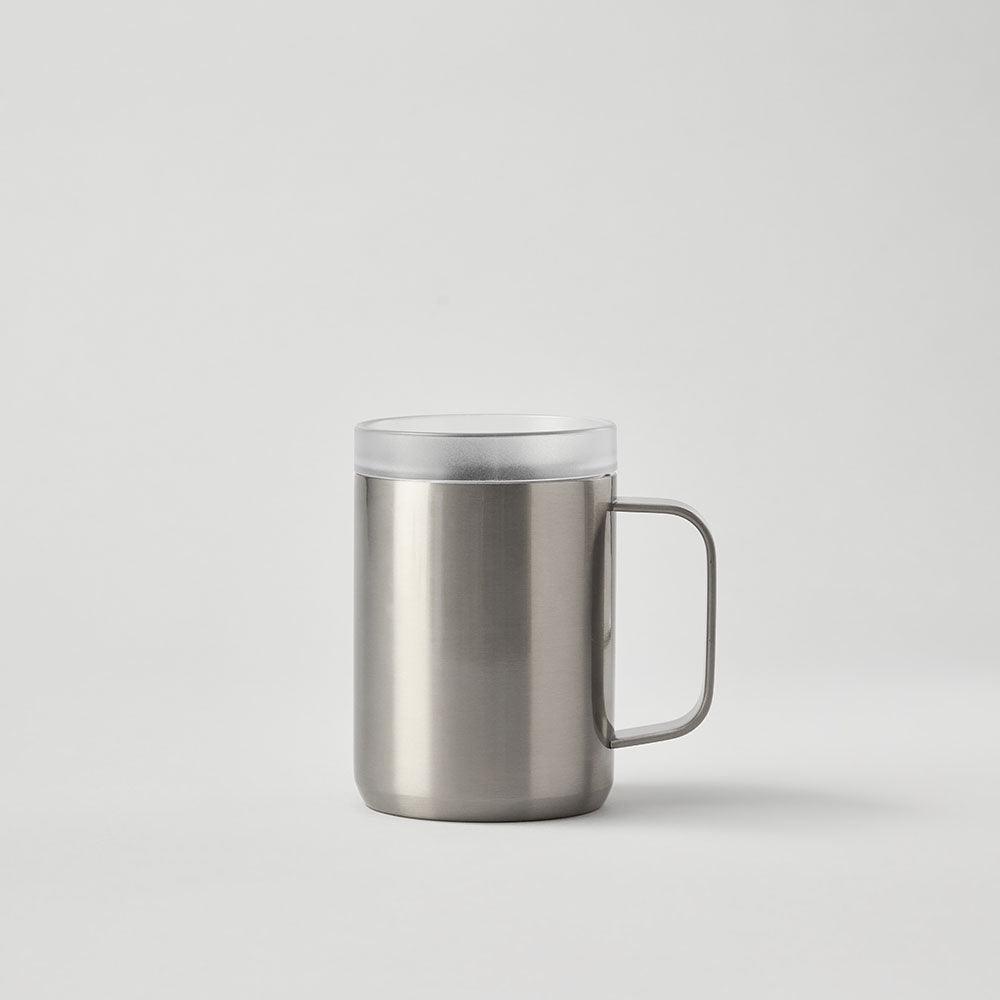 Stainless steel travel mug with handle and clear lid on plain background