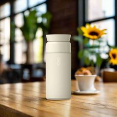 Sandstone reusable Ocean Bottle Brew on wooden table in bright cafe setting