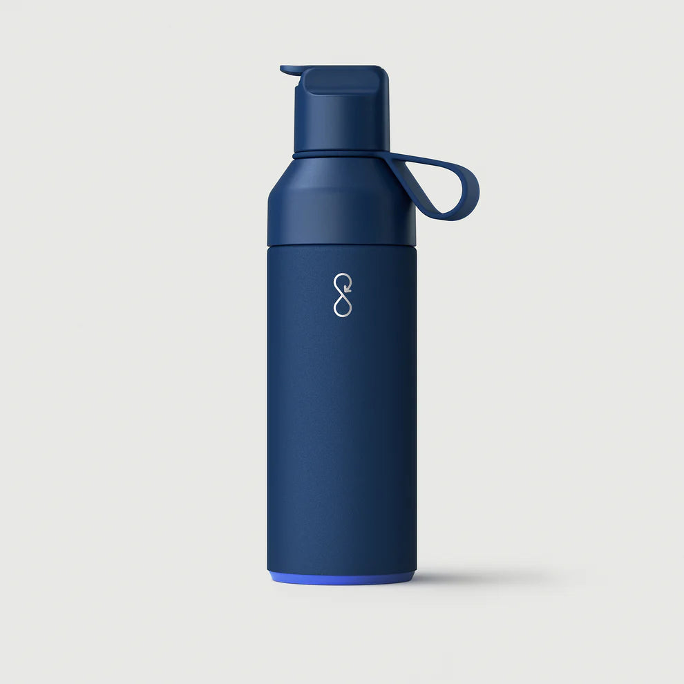 Ocean Bottle GO in ocean blue with logo, reusable insulated water bottle on light background