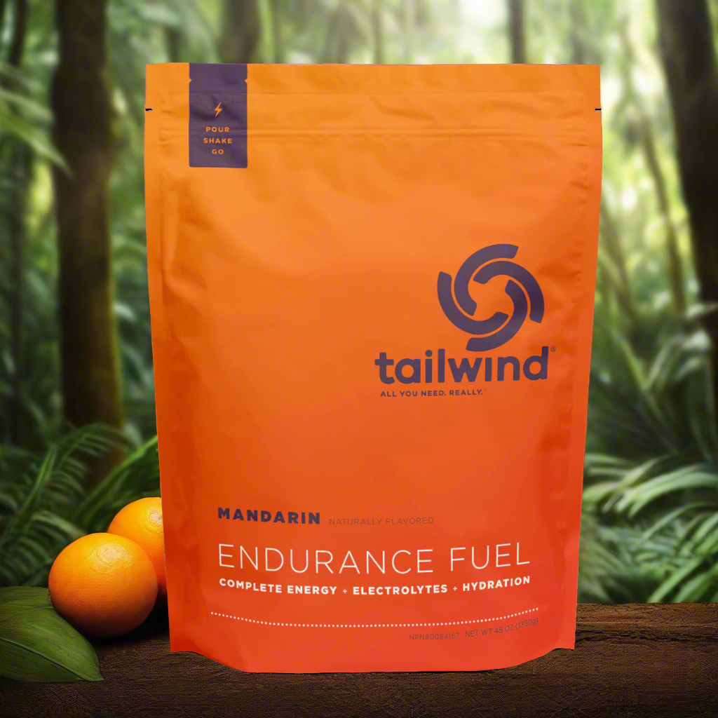 Tailwind Endurance Fuel Mandarin energy powder orange pouch with oranges, jungle background
