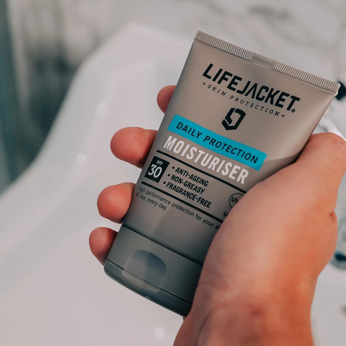 Hand holding LifeJacket SPF 30 Daily Protection Moisturiser in bathroom setting