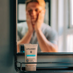 LifeJacket SPF 30 Daily Protection Moisturiser tube on bathroom shelf, man in mirror background