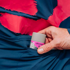 Hand placing LifeJacket SPF 50+ mineral sun stick in dark blue pocket