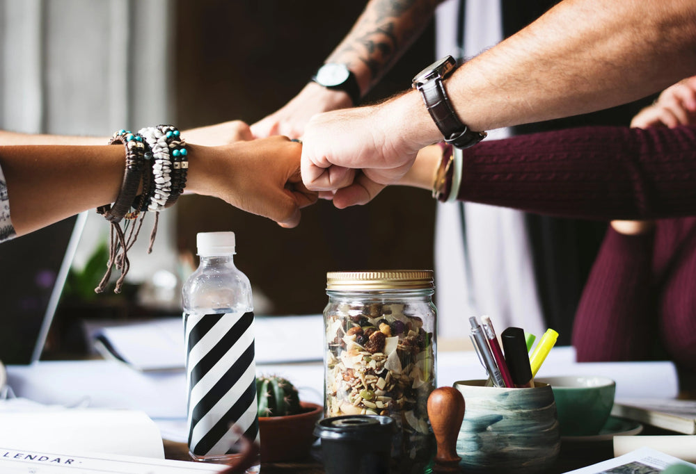 Two colleagues sharing a fist bump across a desk