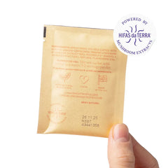 Hand holding a London Nootropics mushroom coffee sachet with ingredients and vegan icons, Hifas da Terra logo.