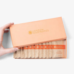 Hand opening London Nootropics Flow nootropic coffee sachets box on white background