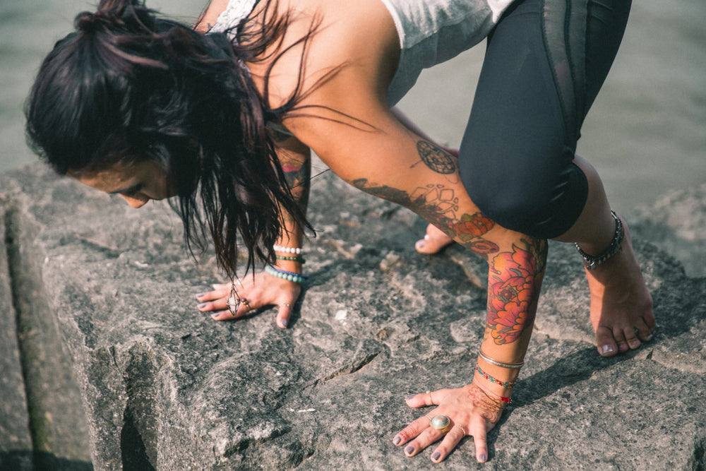 Person practising yoga on coastal rocks