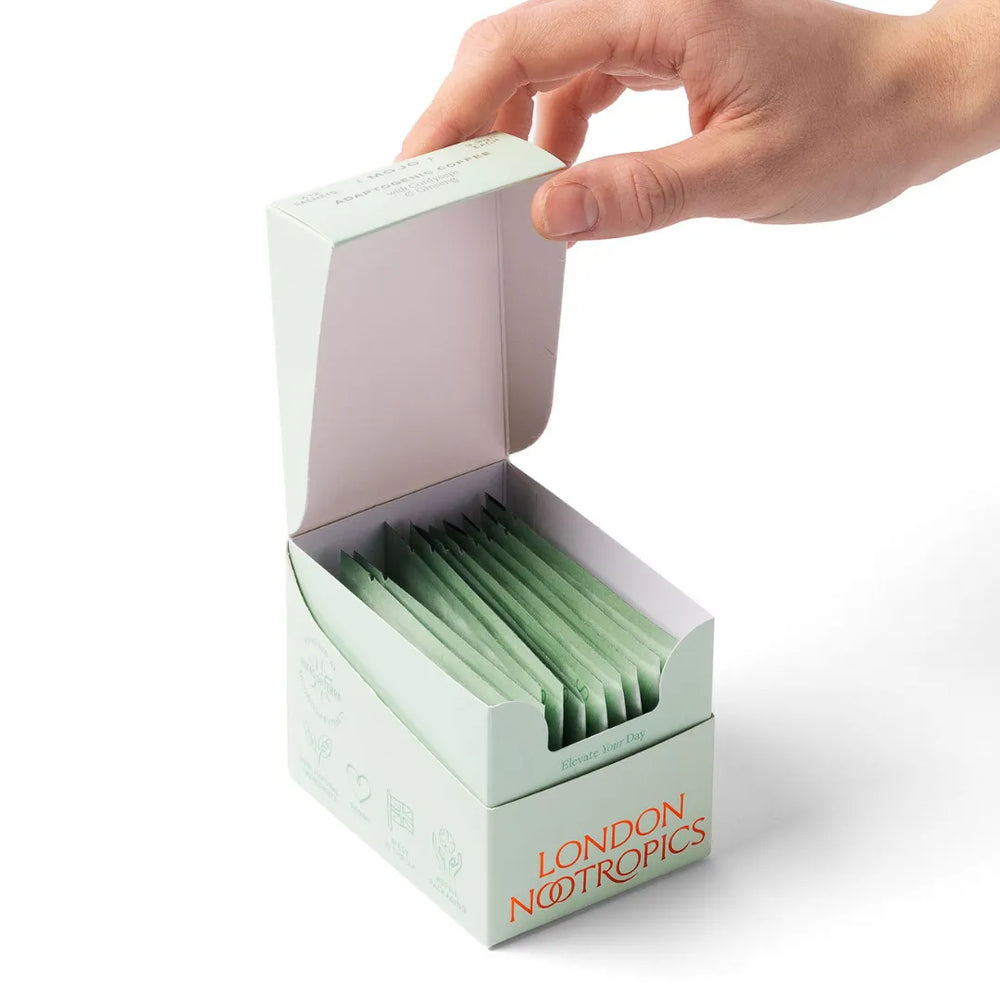 Hand opening London Nootropics Mojo coffee box with sachets on white background
