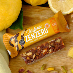 Veloforte Zenzero energy bar lemon ginger pistachio flavor with ingredients on wooden board