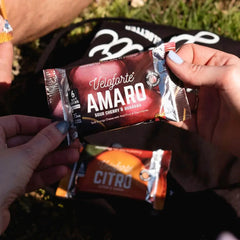 Hands holding Veloforte Amaro natural energy chews, sour cherry and guarana flavor outdoors