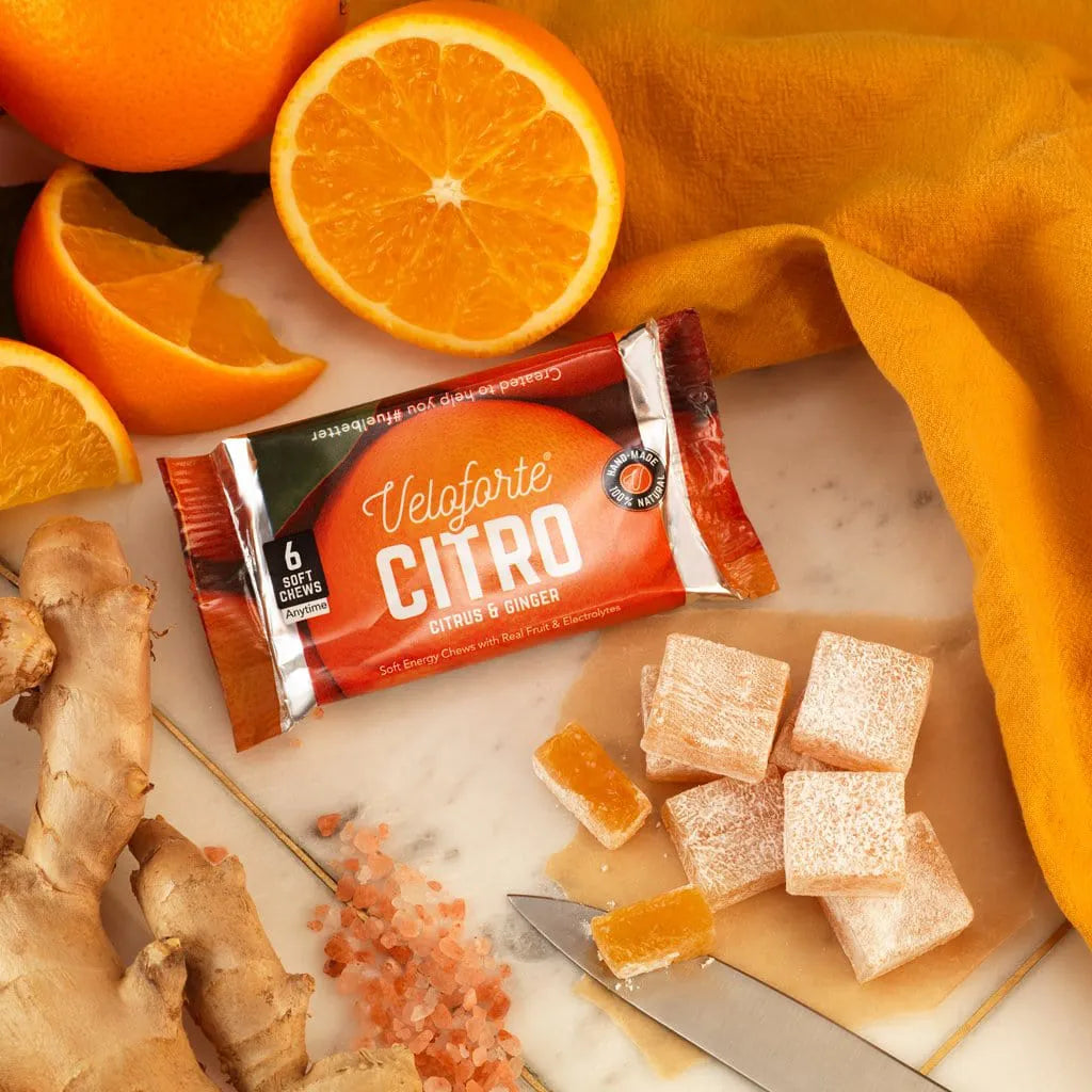 Veloforte Citro citrus ginger energy chews with sliced oranges, ginger, and salt on marble.