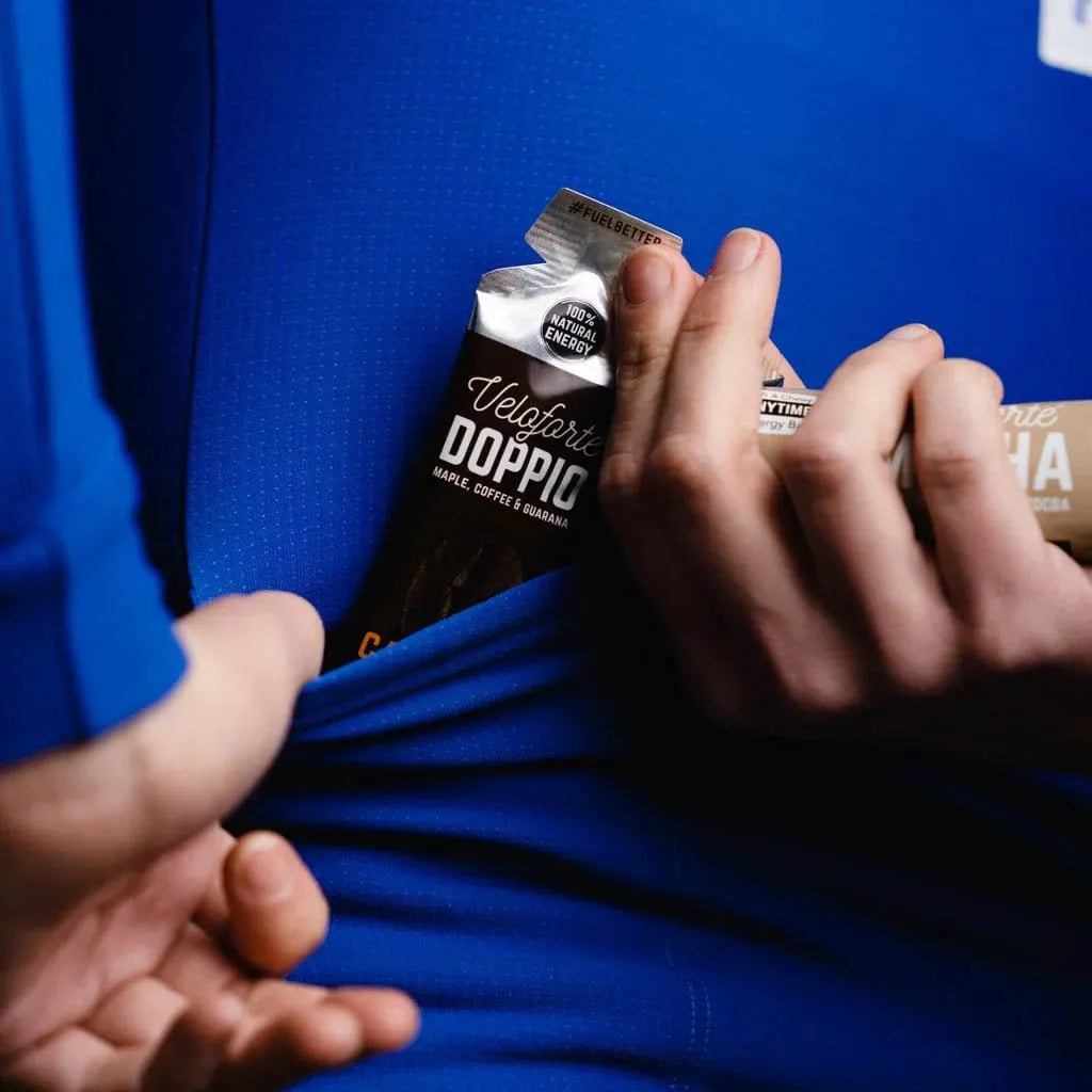 A hand opening a Veloforte Doppio energy gel